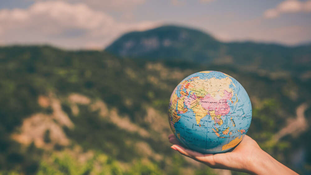 A hand holding a globe.